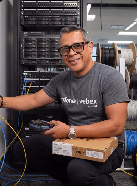 IPFone technician working in a network rack with fiber cabling